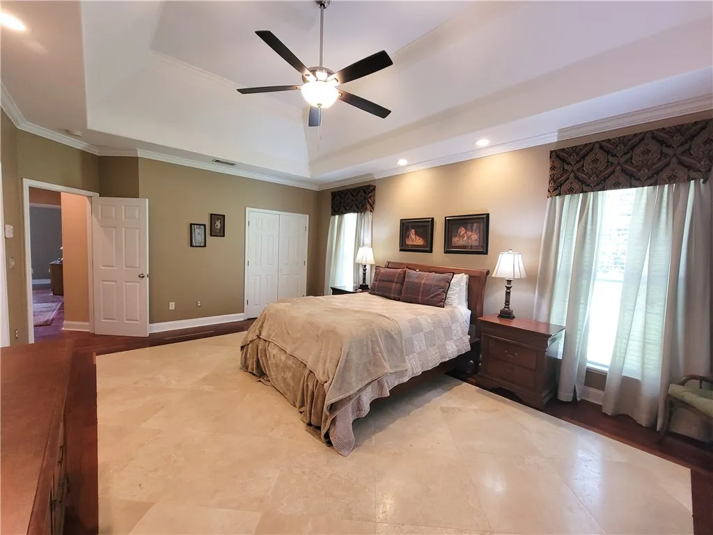 Elegant crown molding accents a bedroom with both hardwood and tile flooring.