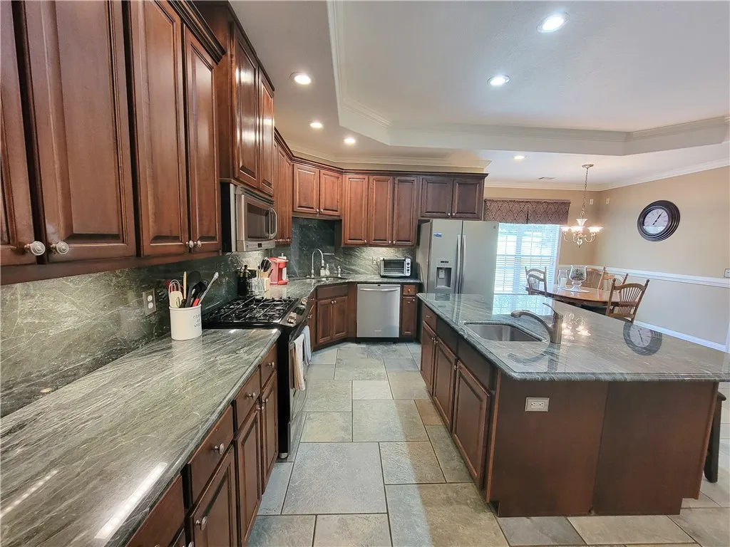Premium granite countertops complement rich cabinetry in this inviting kitchen, perfect for culinary adventures.