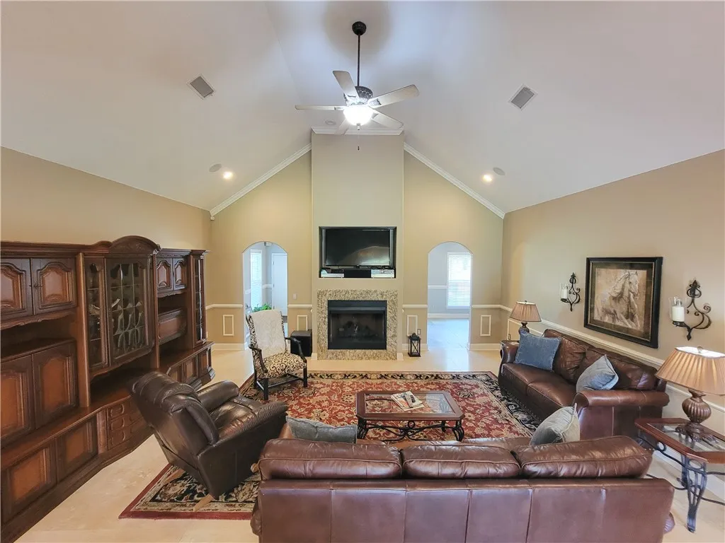 A spacious great room showcases high vaulted ceilings and a classic fireplace.