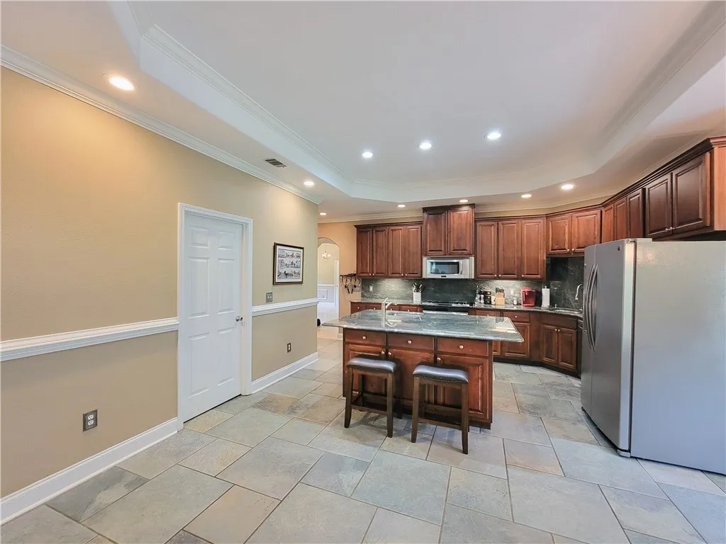 Chef's dream kitchen offers rich wood cabinetry, granite countertops, and modern stainless steel appliances.