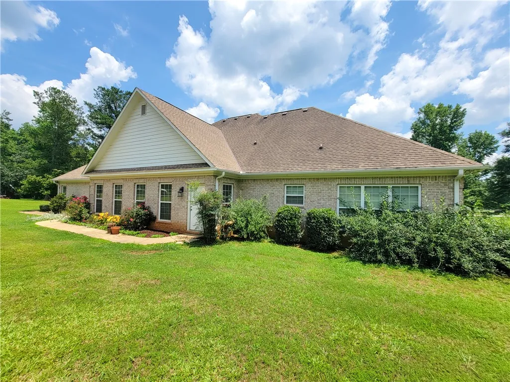 A classic brick exterior blends seamlessly with lush landscaping and a well-kept lawn.
