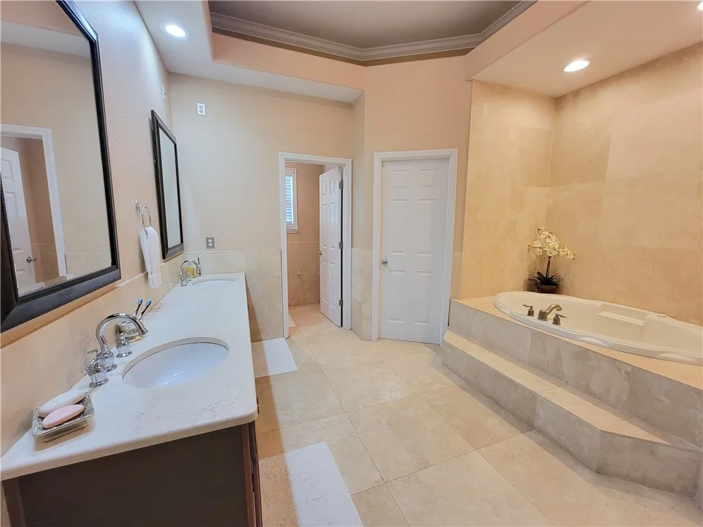 Luxurious bathing quarters with a generously sized soaking tub and dual vanities.