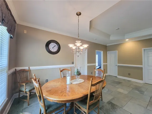 Natural light illuminates the room, accentuating the high ceilings and elegant crown molding.