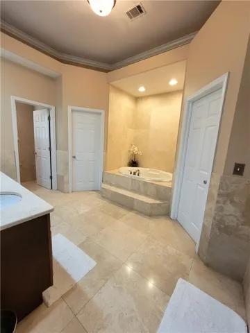 Indulge in a primary bathroom featuring an inviting built-in tub and extensive tile work.