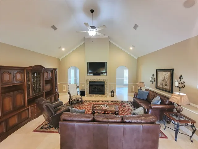 A striking fireplace forms the focal point in this welcoming living area, complemented by high vaulted ceilings.