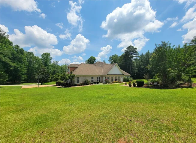 A classic brick exterior blends seamlessly with the vast, verdant lawn.