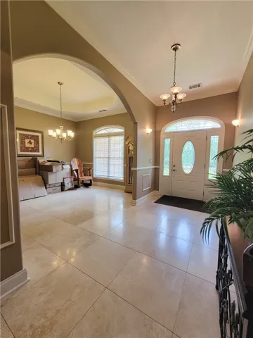 Step into a luminous entryway featuring an arched doorway and polished tile flooring.