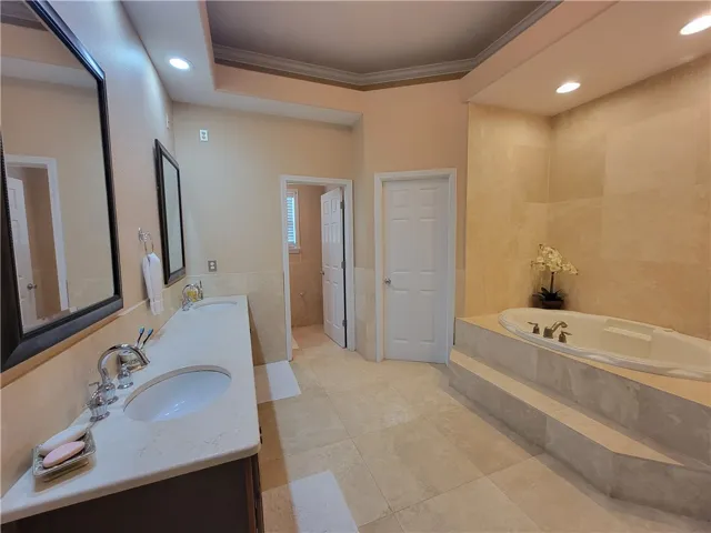 Luxurious primary bath with double vanity, recessed lighting, and a grand soaking tub.
