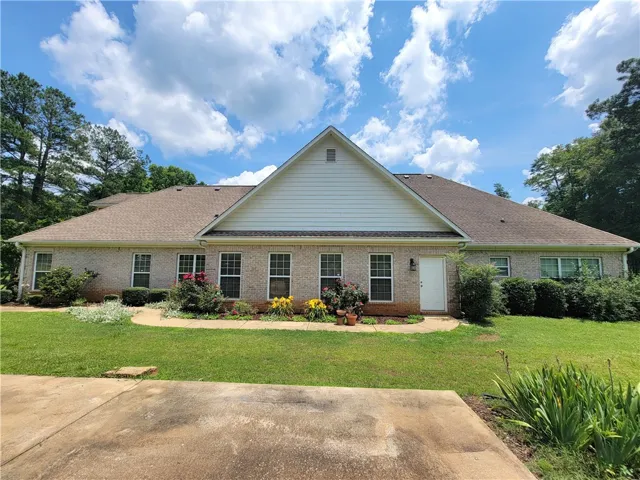 Timeless brick home surrounded by mature landscaping and a verdant lawn.