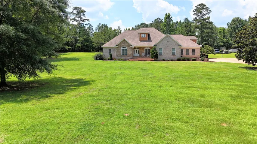 A spacious front lawn provides a welcoming approach to this traditional brick home with an inviting dormer.
