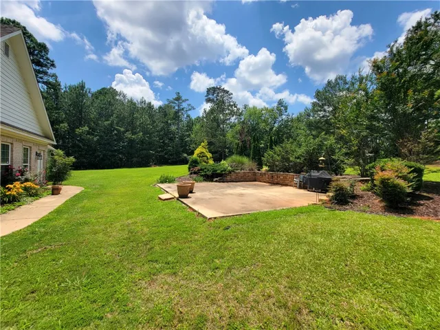 A spacious lawn provides ample outdoor enjoyment with a concrete patio perfect for entertaining.
