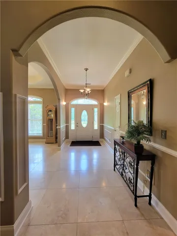 Arched doorways and a decorative chandelier define this inviting entryway.