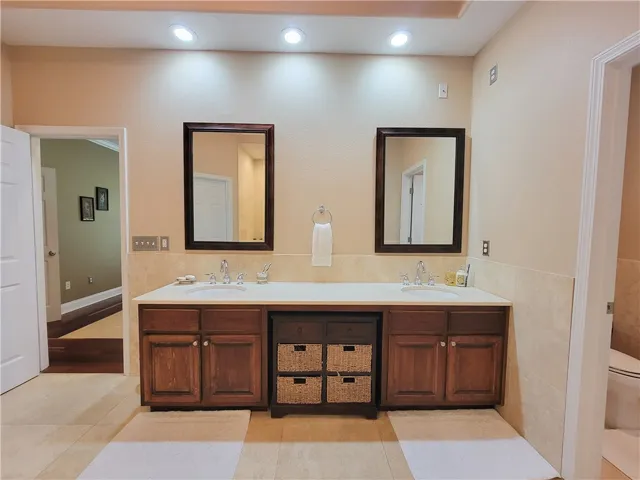 Dual vanities with ample counter space create a serene and practical bathing area.