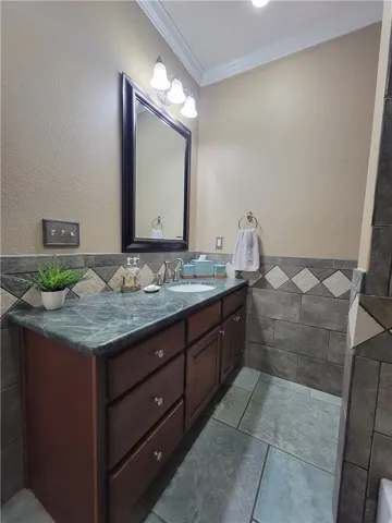 A well-appointed bathroom with crown molding and a handsome vanity, offering both style and utility.