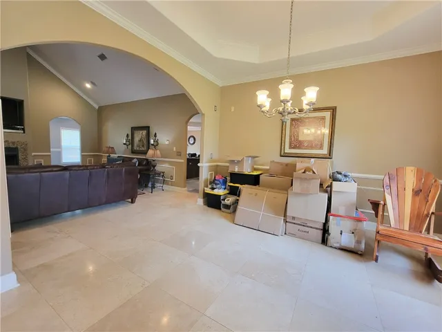 Natural light illuminates this spacious living area with vaulted ceilings and elegant crown molding.