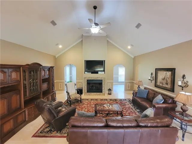 A spacious great room showcases high vaulted ceilings and a classic fireplace.