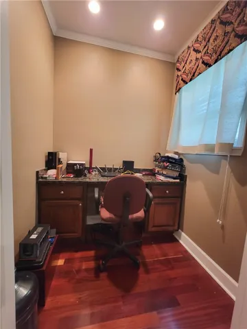 Hardwood flooring grounds a versatile office space, complete with built-in cabinetry and task lighting.