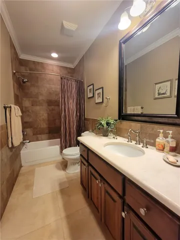 A well-appointed bath with tiled shower and ample counter space.