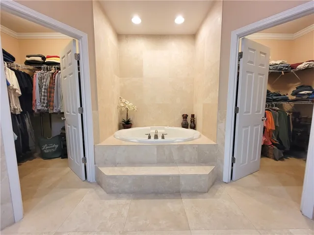 Indulge in a relaxing soak within this primary bathroom featuring a spacious built-in tub.