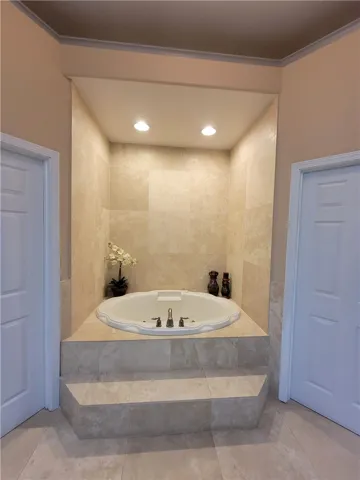 Indulge in a tranquil bathing experience with this built-in soaking tub, framed by elegant tile work.