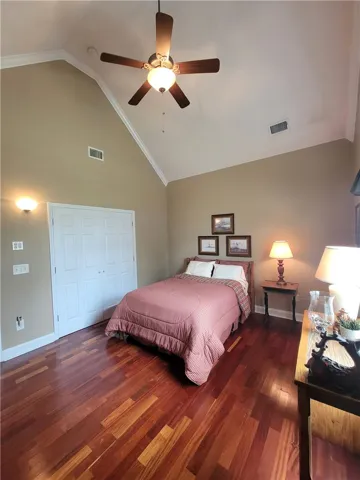 Rich hardwood flooring complements soaring vaulted ceilings in this inviting bedroom retreat.
