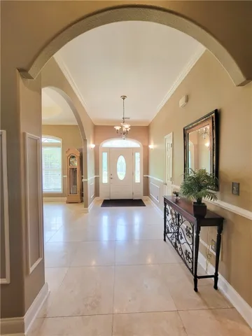 Step into a gracious entrance foyer, featuring arched doorways and polished tile flooring.