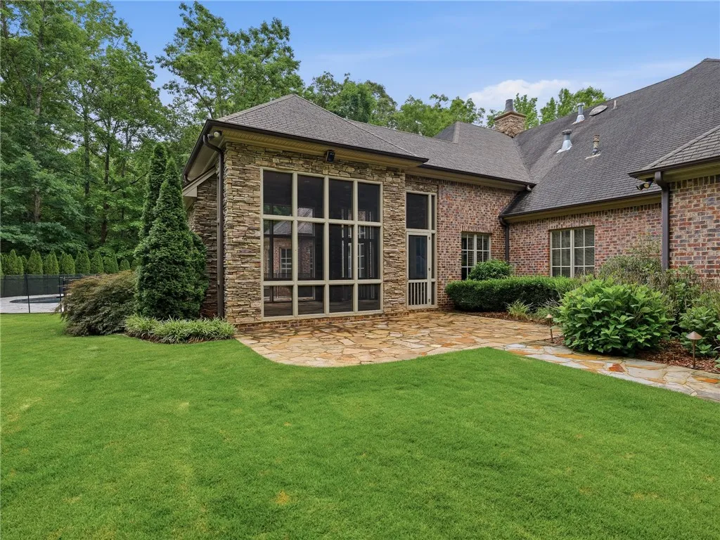 A flagstone patio provides a pleasant outdoor setting for this elegant brick and stone residence.