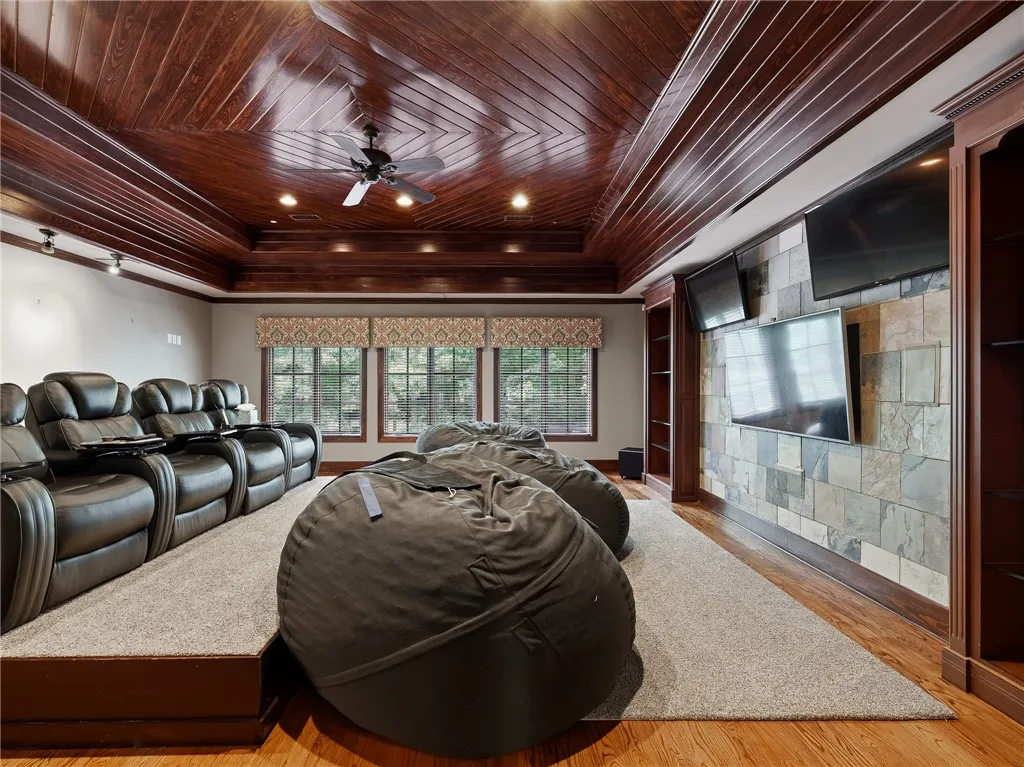 A spacious home theater featuring a stunning wood plank ceiling and plush tiered seating for entertainment.