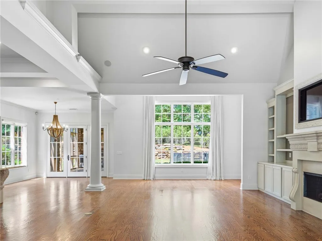 Polished hardwood floors and built-in shelving anchor this airy living space with high ceilings.