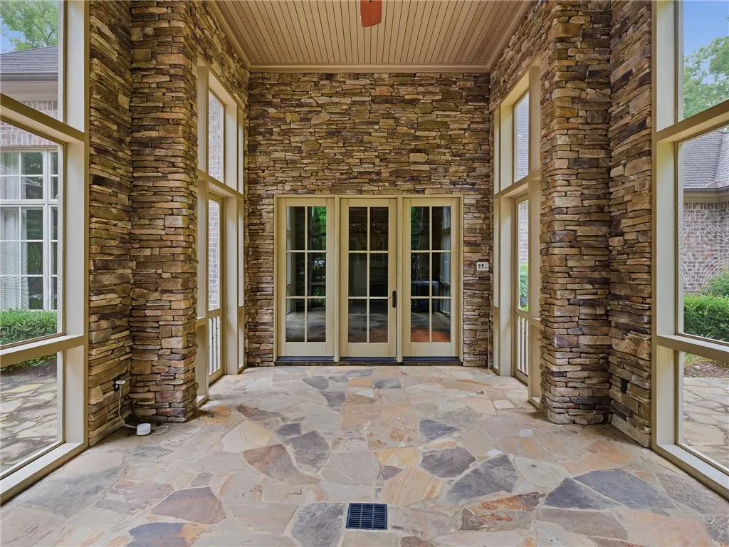 An inviting stone patio with glass doors offers a refined outdoor living space.
