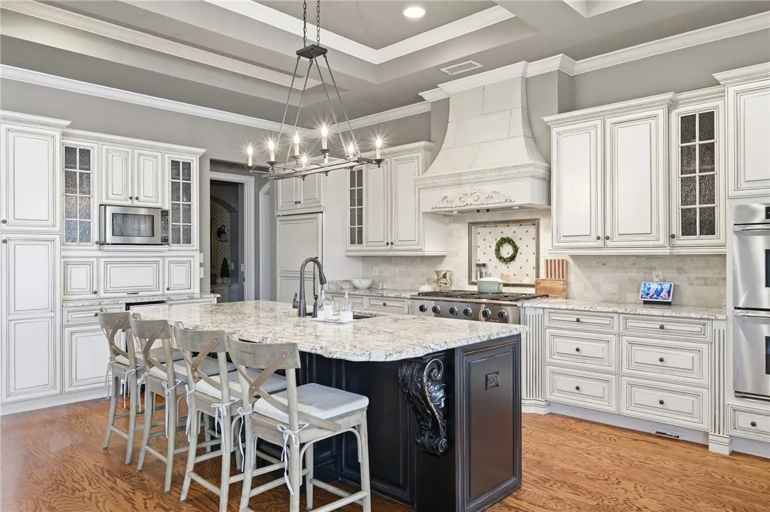 A well-appointed culinary space featuring extensive cabinetry and a central island with bar seating.