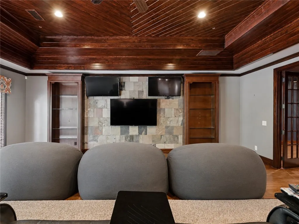 Rich wood paneling graces the ceiling and built-ins of this comfortable media room.