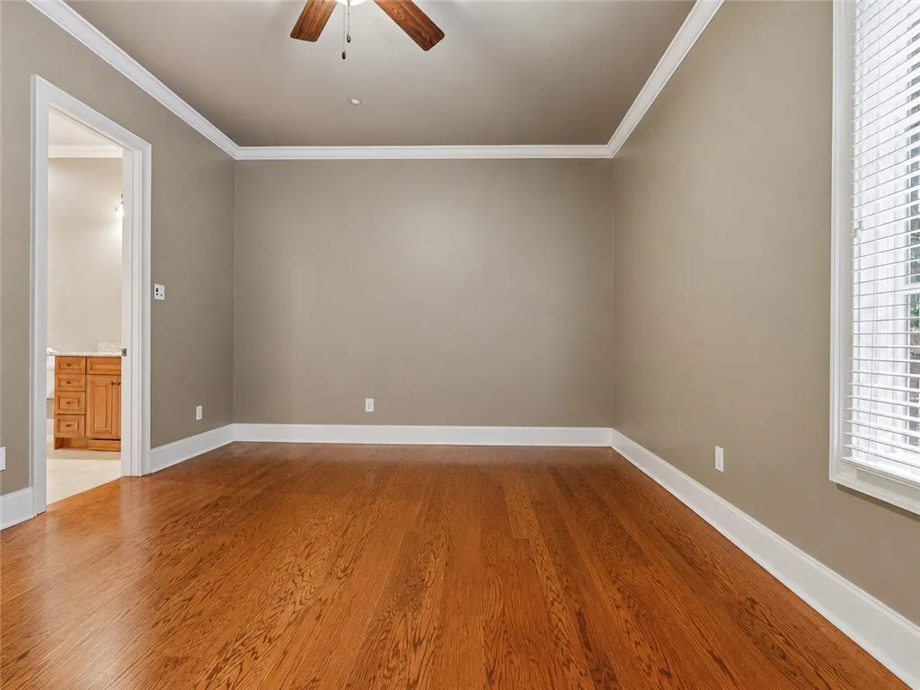 Rich hardwood flooring extends throughout this versatile living area, perfect for a cozy den or additional sleeping quarters.
