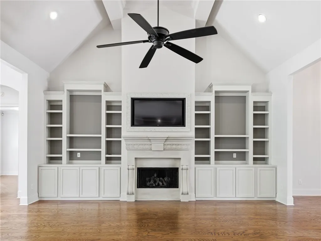 Gleaming hardwood floors and a towering vaulted ceiling anchor this grand living area.