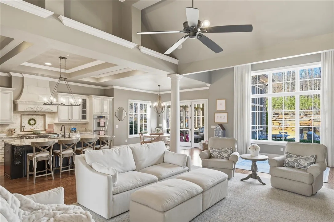 An open-concept interior unfolds with soaring ceilings and rich hardwood flooring, blending living and kitchen areas seamlessly.