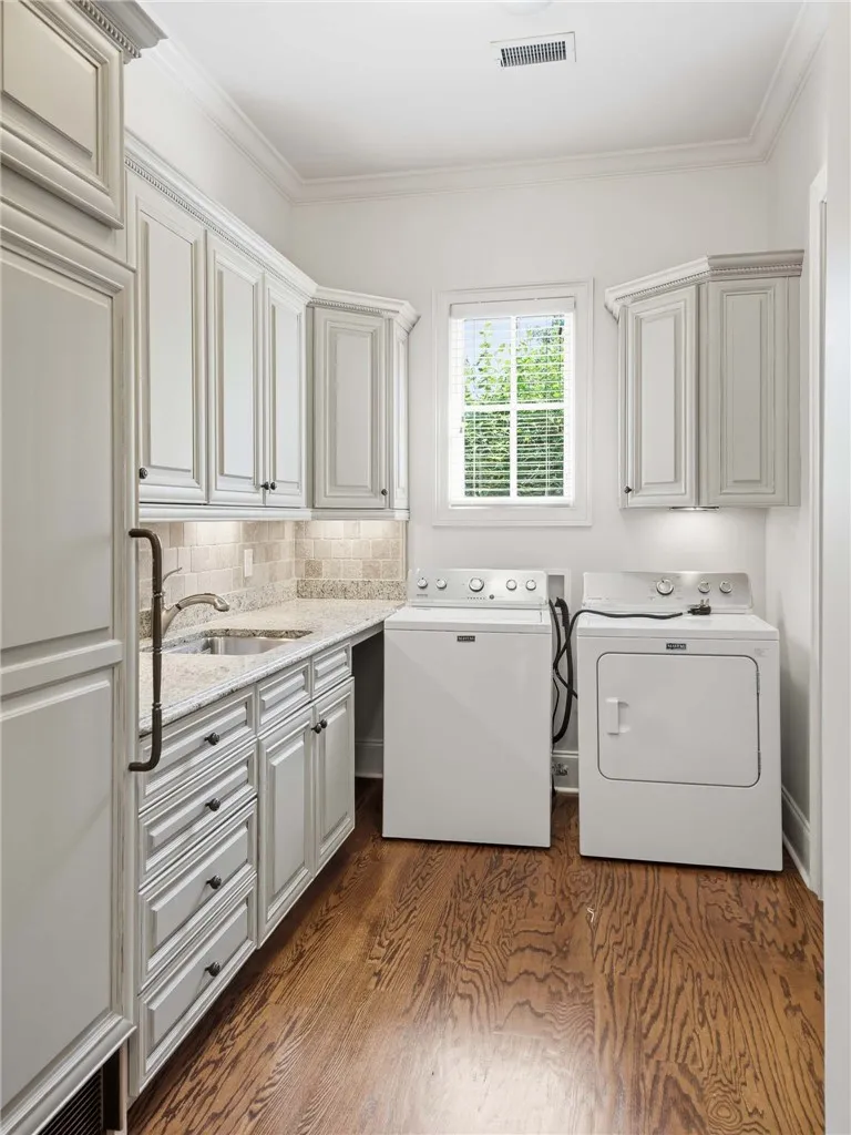 Crown molding and rich hardwood flooring frame this highly functional utility space with ample cabinetry.