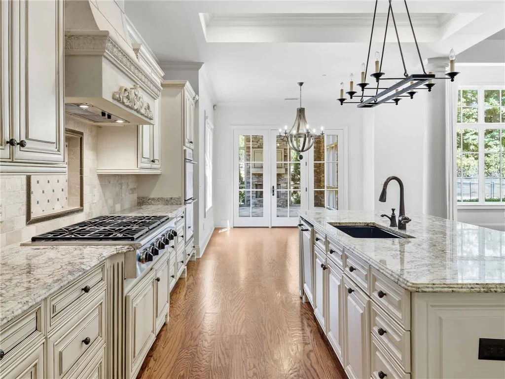 Rich hardwood floors complement elegant stone countertops and a spacious central island.