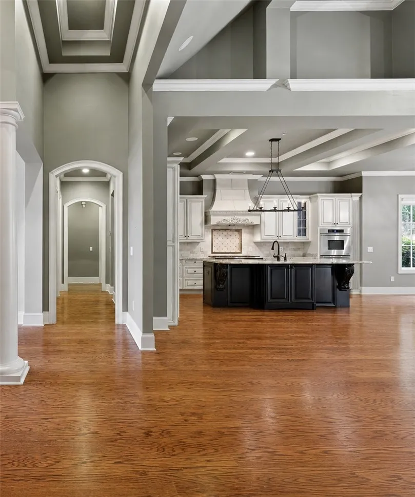 Refined wood flooring flows into a well-appointed kitchen, featuring a spacious island.