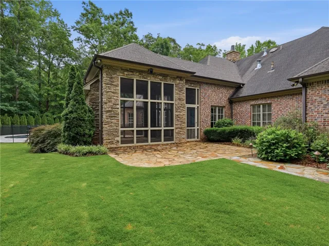 A flagstone patio provides a pleasant outdoor setting for this elegant brick and stone residence.