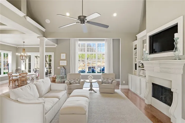 A refined living space showcases a built-in media center, an elegant fireplace, and abundant natural light.