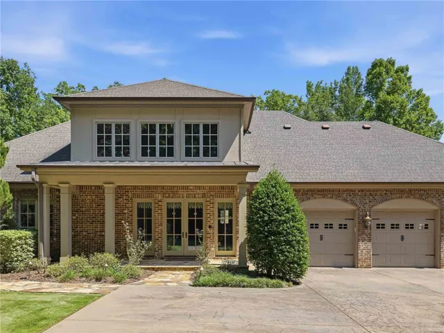 An inviting stone path leads to the columned side porch of this stately brick home with 3 car garage.