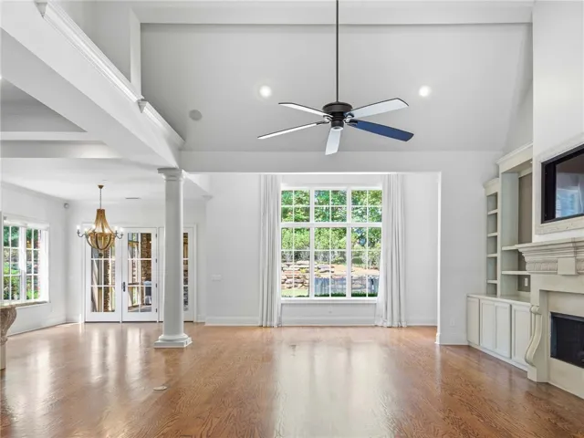 Polished hardwood floors and built-in shelving anchor this airy living space with high ceilings.