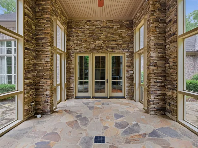 An inviting stone patio with glass doors offers a refined outdoor living space.