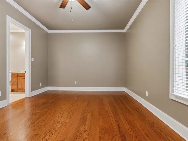 Rich hardwood flooring extends throughout this versatile living area, perfect for a cozy den or additional sleeping quarters.