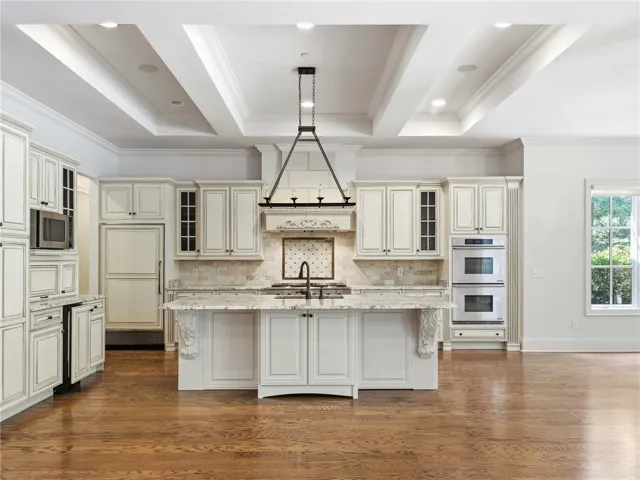 Gleaming hardwood floors and a coffered ceiling elevate this classic kitchen with a large island.