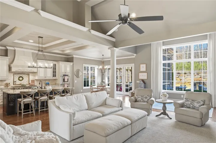 An open-concept interior unfolds with soaring ceilings and rich hardwood flooring, blending living and kitchen areas seamlessly.