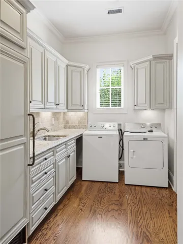 Crown molding and rich hardwood flooring frame this highly functional utility space with ample cabinetry.