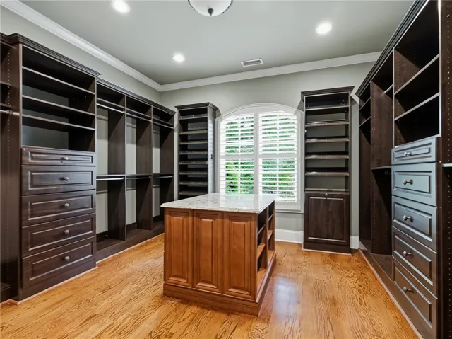Custom-designed storage solutions and natural light fill this spacious walk-in closet.