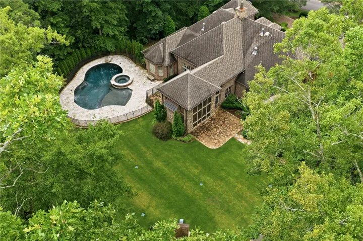 An aerial perspective reveals a private pool and spa, complementing the extensive green yard space.