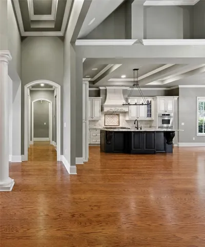 Refined wood flooring flows into a well-appointed kitchen, featuring a spacious island.